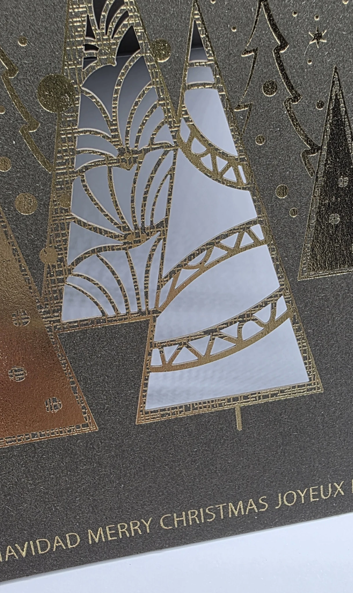 Filigraner Lasercut mit goldener Heißfolienprägung auf dunklem Papier